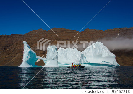 Landscape with iceberg in Greenland at summer time. Sunny weather. Inflatable boat with tourists. Landscape with iceberg in Greenland at summer time. Sunny weather. Inflatable boat with tourists. 95467218