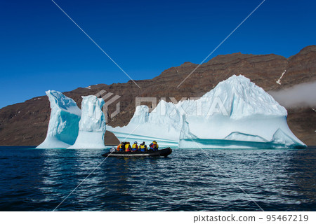 Landscape with iceberg in Greenland at summer time. Sunny weather. Inflatable boat with tourists. Landscape with iceberg in Greenland at summer time. Sunny weather. Inflatable boat with tourists. 95467219
