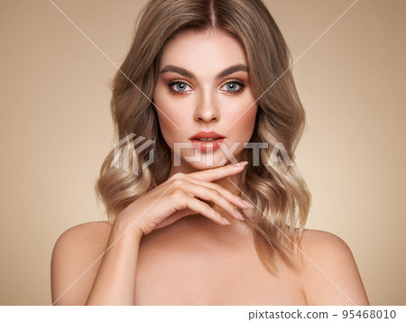 A beautiful young woman with shiny wavy blonde hair A beautiful young woman with shiny wavy blonde hair 95468010