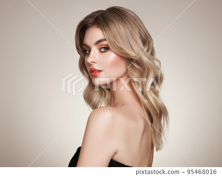 A beautiful young woman with shiny wavy blonde hair A beautiful young woman with shiny wavy blonde hair 95468016