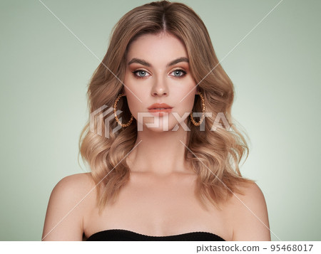 A beautiful young woman with shiny wavy blonde hair A beautiful young woman with shiny wavy blonde hair 95468017