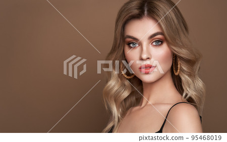 A beautiful young woman with shiny wavy blonde hair A beautiful young woman with shiny wavy blonde hair 95468019