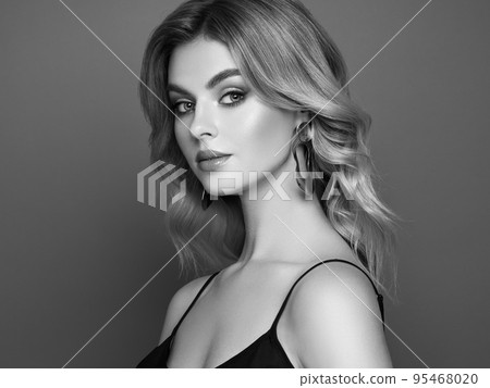A beautiful young woman with shiny wavy blonde hair 95468020