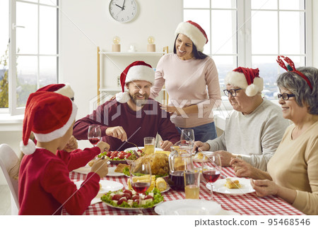 Young woman takes care of her family during traditional Christmas holiday breakfast meal at home. 95468546