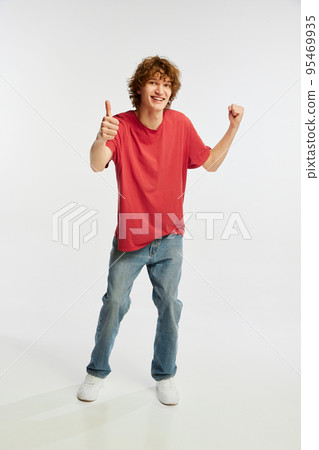 Astonished young man thumb up and smiling isolated over white background. Youth emotions, youth, sales, ad 95469935