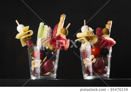 Jarcuterie in a glasses, the modern version of charcuterie. includes various types of sausages, pickles and cheese, sometimes vegetables or fruits. hero view angle 95470239