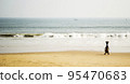 Woman carrying a basket on the beach 95470683