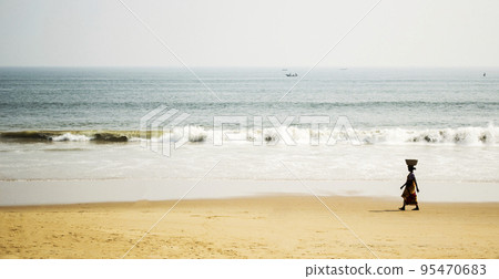 Woman carrying a basket on the beach Woman carrying a basket on the beach 95470683