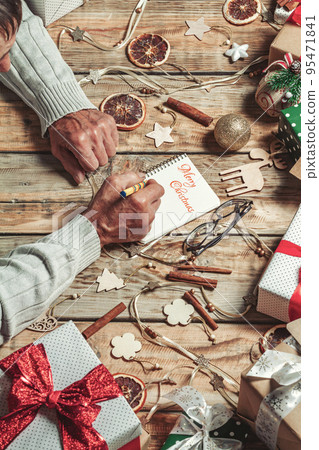 Elderly senior hands writing letter to santa or Merry Christmas 95471841