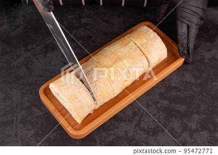 dessert meringue roll with fresh pear on a dark background in a coffee shop. 95472771