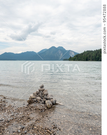 Lake shore. Balanced stones stack. Near Alps peak 95472888