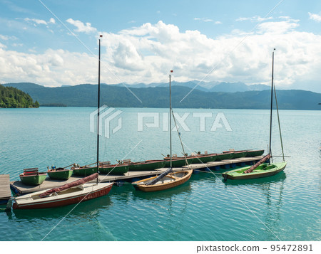 Pier with rental row boats and yachts at mountain lake Walchensee 95472891