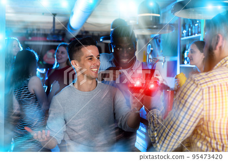 Friends clinking glasses with cocktails at night club 95473420