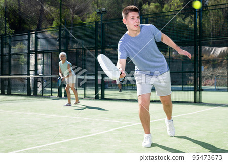 Man training to play tennis on padel court outdoor Man training to play tennis on padel court outdoor 95473673