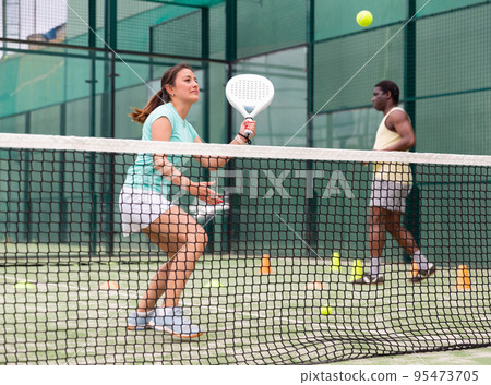 Portrait of young woman during padel training Portrait of young woman during padel training 95473705