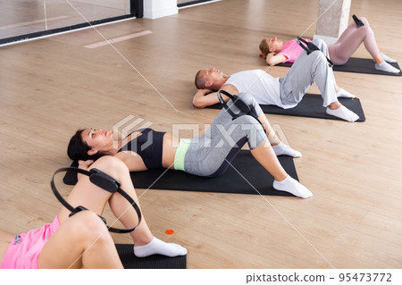 Group of peple exercising with pilates ring Group of peple exercising with pilates ring 95473772