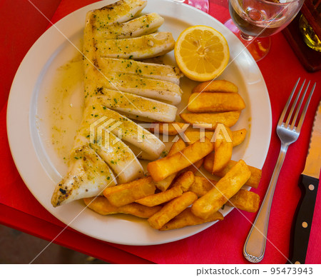 Fried squid served with baked potatoes Fried squid served with baked potatoes 95473943