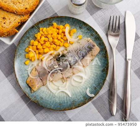 Pickled herring slices with canned corn kernels and onions Pickled herring slices with canned corn kernels and onions 95473950