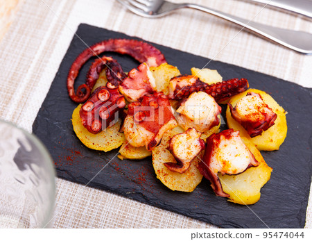 Portion of polbo a feira served on board 95474044