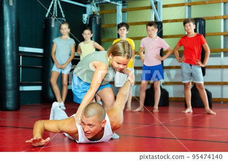 Young schoolgirl practicing basic self-defense moves 95474140