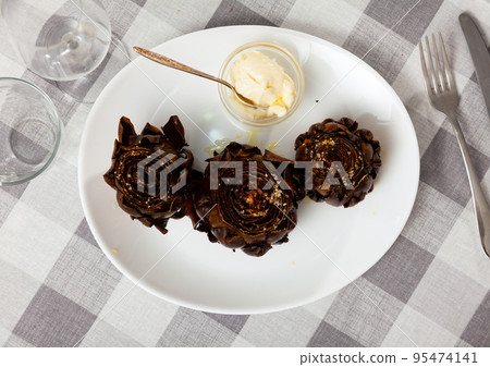 Three whole roasted artichokes with hollandaise sauce 95474141