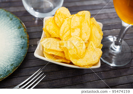 Potato chips served with glass of beer Potato chips served with glass of beer 95474159