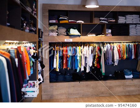 Interior of male clothing store with clothes on hangers and shelves 95474160