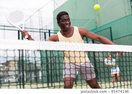 Sporty emotional man playing doubles paddle tennis 95474196