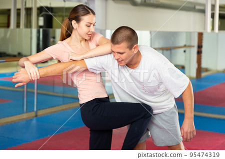 Woman performing knee strike during self-defence training Woman performing knee strike during self-defence training 95474319