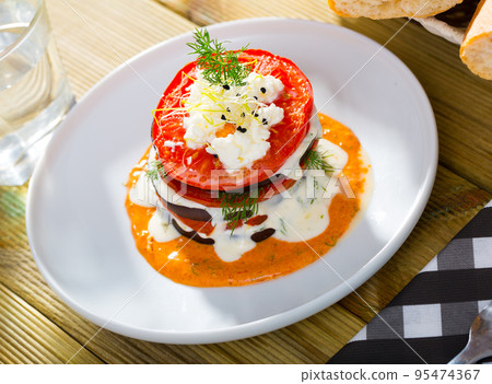 Dish of tasty eggplants with tomatoes on spicy sauce at white plate 95474367