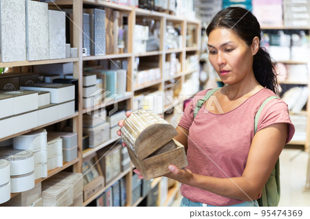 Asian woman choosing storage container at store Asian woman choosing storage container at store 95474369
