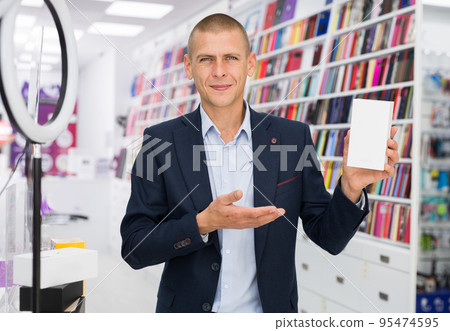 Positive man holding box for phone at multimedia store Positive man holding box for phone at multimedia store 95474595