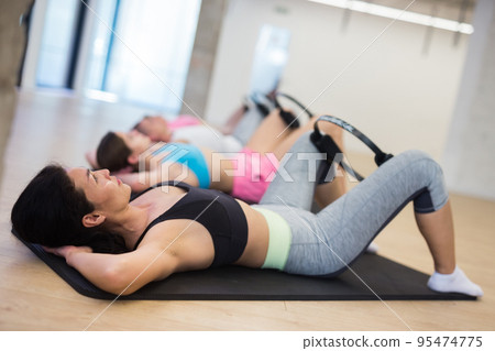 Young adult woman exercising with pilates ring Young adult woman exercising with pilates ring 95474775