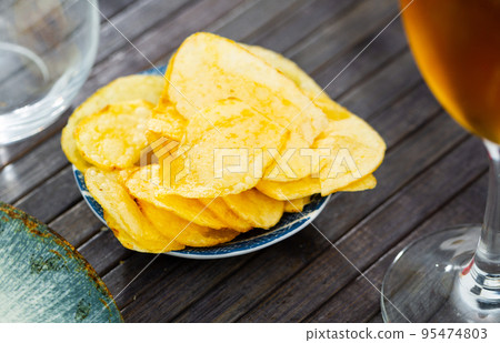 Potato chips and beer served on table Potato chips and beer served on table 95474803