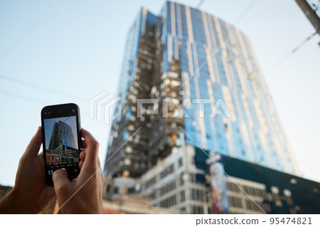 The man photographs business center building was hit by Russian shelling in Kyiv, Ukraine. 95474821
