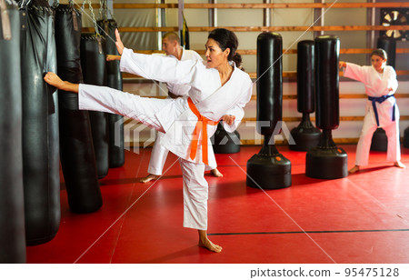 Asian Woman is practicing different kicks Asian Woman is practicing different kicks 95475128