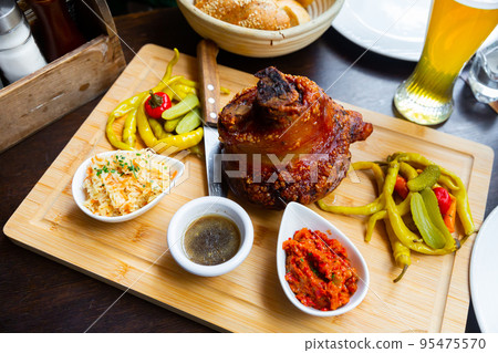 Popular dish of Austrian cuisine is roasted pork knuckle in beer sauce Popular dish of Austrian cuisine is roasted pork knuckle in beer sauce 95475570
