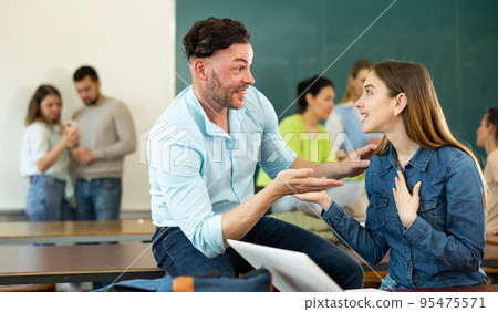 Positive student is chatting with a fellow student girl Positive student is chatting with a fellow student girl 95475571