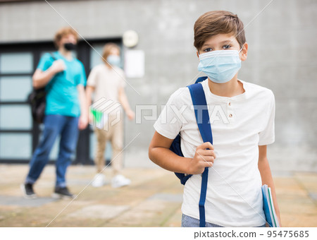 Portrait of teenager boy in protective mask going to school lessons on summer day Portrait of teenager boy in protective mask going to school lessons on summer day 95475685