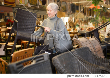 Senior woman looking for plastic rattan garden furniture in store Senior woman looking for plastic rattan garden furniture in store 95475689