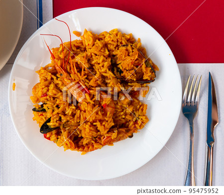 Plate of tasty seafood paella with rice, mussels and shrimps 95475952