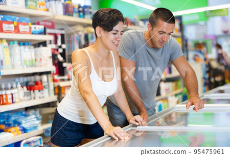 Happy couple choosing frozen convenience food in supermarket 95475961