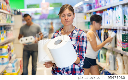 Woman choosing paper towels in supermarket 95475980