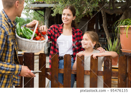 Good neighbors communicate while standing by fence between houses Good neighbors communicate while standing by fence between houses 95476135