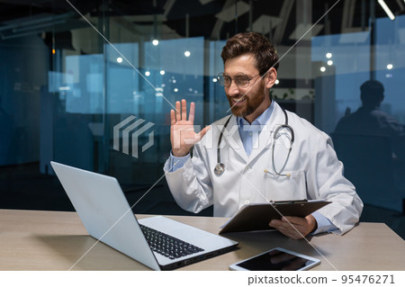 Mature doctor working remotely from modern clinic office, man inside talking on video call with patient using laptop Mature doctor working remotely from modern clinic office, man inside talking on video call with patient using laptop 95476271