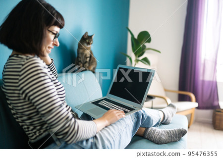 Beautiful woman working on laptop at home. Black screen on laptop. Technology, freelance. Beautiful woman working on laptop at home. Black screen on laptop. Technology, freelance. 95476355