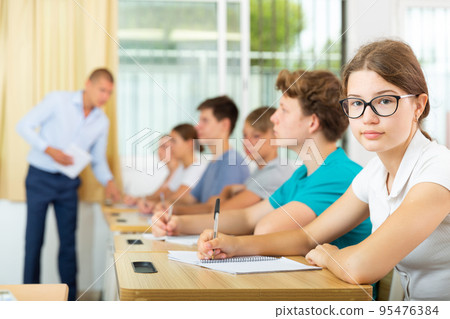 Pupils sitting in class and listening 95476384