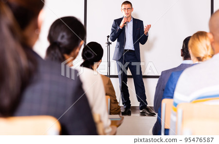 Confident lecturer speaking to businesspeople at seminar Confident lecturer speaking to businesspeople at seminar 95476587