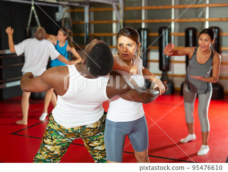 Men and women exercising during self-defence training Men and women exercising during self-defence training 95476610
