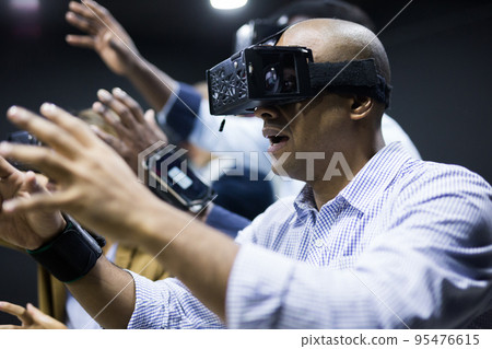 Man using virtual reality headset and smiling 95476615